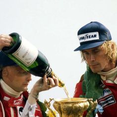 two men are pouring champagne into a gold cup