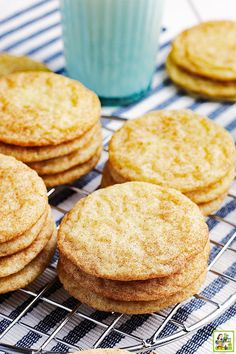 several cookies on a cooling rack next to a glass of milk