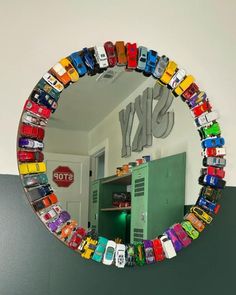 there is a mirror that has cars on it in front of a wall with the word sky painted on it