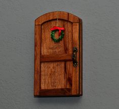 a wooden door with a wreath hanging on it's side and a red ribbon