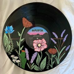 a black record with flowers painted on it