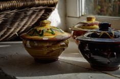 three ceramic containers sitting on top of a table