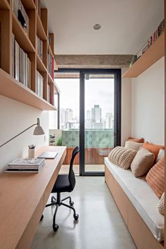 a room with a desk, bookshelf and chair in front of a sliding glass door