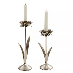 two silver candlesticks sitting next to each other