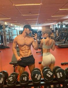 a man and woman standing next to each other in a gym