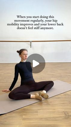 a woman sitting on a yoga mat with her legs crossed