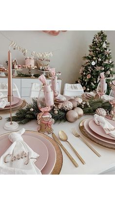 a table set for christmas with pink and gold decorations