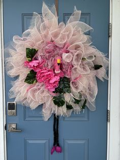 a bouquet of pink flowers is hanging on the front door to decorate it's entrance