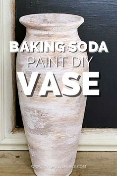 a white vase sitting in front of a black wall with the words baking soda painted on it