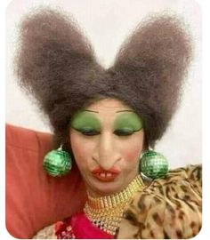 a woman with an afro and green makeup