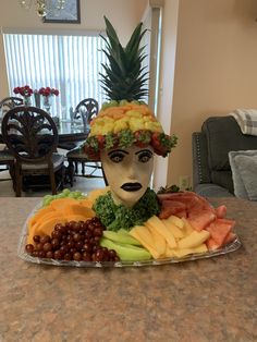 a plate with fruit on top of it and a man's face made out of fruits