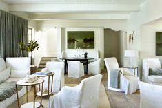 a living room filled with white furniture and decor