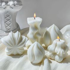 some white candles sitting on top of a table