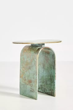 a metal table with a glass top on the bottom and an oval shaped base in the middle