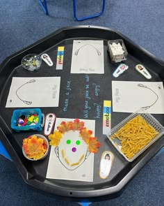 a black tray topped with lots of different types of food and writing on the table