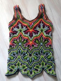 a crocheted tank top sitting on the floor