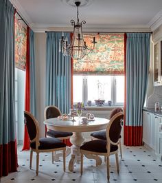 a dining room table with four chairs and a chandelier hanging from the ceiling