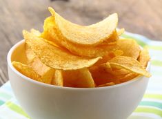 a white bowl filled with potato chips on top of a table