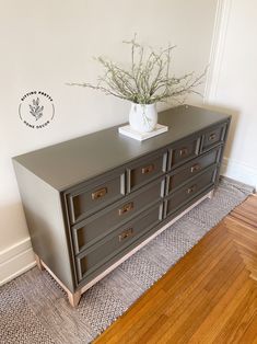 a large gray dresser sitting on top of a hard wood floor next to a wall