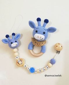 two crocheted giraffes are next to a pacifier