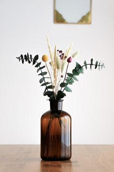 a vase filled with flowers on top of a wooden table