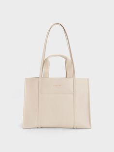 If you have an affinity for neutrals, the Shalia bag is a must-have addition to your collection. With its double top handles and versatile strap, this gem offers multiple styling options. The soft beige shade adds an aesthetically pleasing touch, making you look chic and polished from every angle while effortlessly complementing any ensemble you choose. For a simple yet elegant look, pair it with a pencil skirt and printed blouse combination. Tote Bag For Work, Edgy Bags, Adjustable Bag Strap, Buy Bags, Adjustable Bag, Size Chart For Kids, Charts For Kids, Soft Beige, Charles Keith