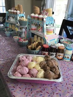 a table topped with lots of different types of ice cream and desserts on top of it