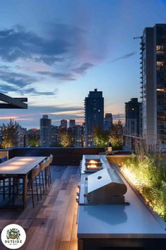 an outdoor dining area on the roof of a high rise building at dusk with city lights in the background