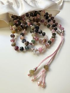 *Handmade natural multi color black tourmaline crystal necklace. *Light pink silk thread and tourmaline beads are knotted.  *The pendant is hand knitted and decorated with silver,  pearl,  tourmaline beads.  *A very strong and balancing  handmade necklace. *Stylish and chic to wear every day. Wearing natural stones will give you confidence. 💌D E T A İ L S Handmade and unique  Suitable for any style  Materials: Silver, Semi-Precious Stones Necklace Length: 37 cm (15 inches) Pendant high: 6 cm (2 inches) 📐L E N G T H  A D J U S T M E N T S Measurements and weight are close approximations. If have concerns about the fit, please send me your measurements. İ will happy to make length adjustments for you. 📌S T O R A G E  A N D  C A R E   Avoid contact with moisture and perfume . When storing,