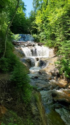 a small waterfall in the middle of a forest