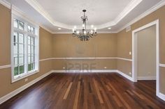 an empty room with wood floors and chandelier