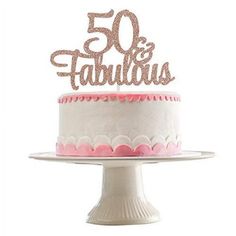 a white cake with pink frosting and the words 50 is fabulous written on top