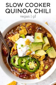 a bowl of slow cooker quinoa chili with avocado and sour cream