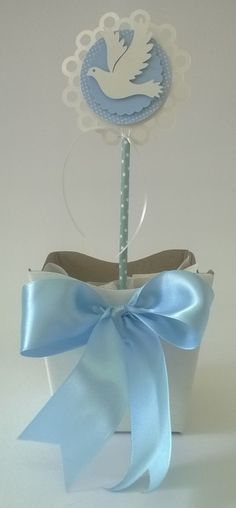 a small blue basket with a white dove on it and a light blue ribbon tied around the top