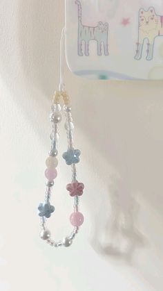 a pair of earrings hanging from a hook with beads and charms attached to the hooks