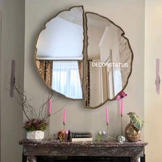 a mirror that is on the wall above a fireplace in a living room with candles