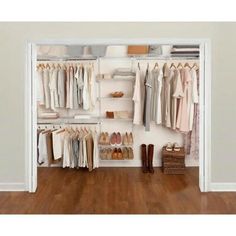 an open closet with clothes and shoes hanging on the wall, in front of a wooden floor