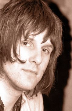 a black and white photo of a man with long hair wearing a shirt and tie