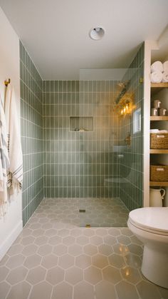 a bathroom with green tiled walls and floor