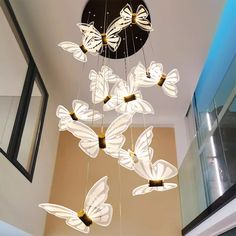 a chandelier with butterflies hanging from it's sides in a room next to a window