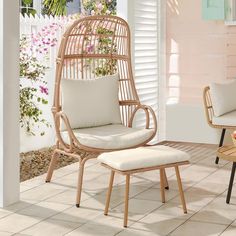 a wicker chair and footstool on a patio with pink flowers in the background