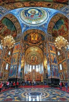 the interior of an ornate church with many paintings on the walls and ceiling, along with chandeliers