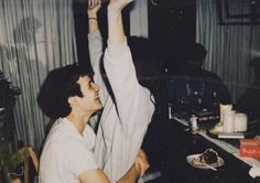 a man is holding up his arms in the air while sitting at a table with other people