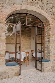 an open glass door leading to a dining area with table and chairs in the background