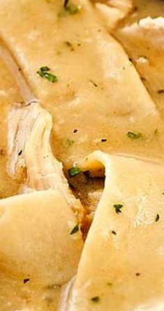 a close up view of some food in a bowl with broth and parsley