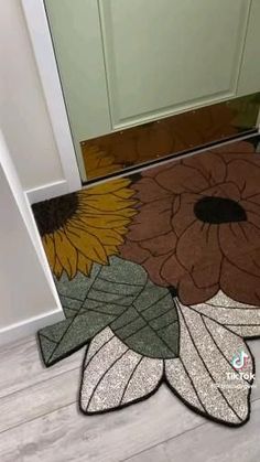 a door mat with sunflowers and leaves on it