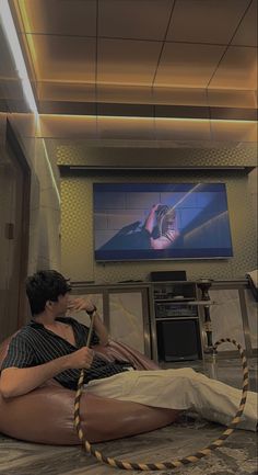 a woman sitting on the floor in front of a flat screen tv