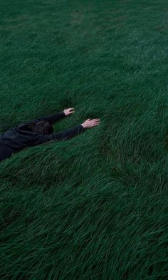 a person laying in the grass with their arms out