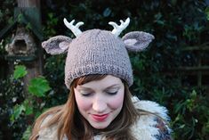 a girl wearing a knitted hat with deer antlers on it