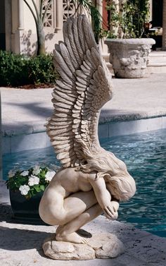 an angel statue sitting next to a pool